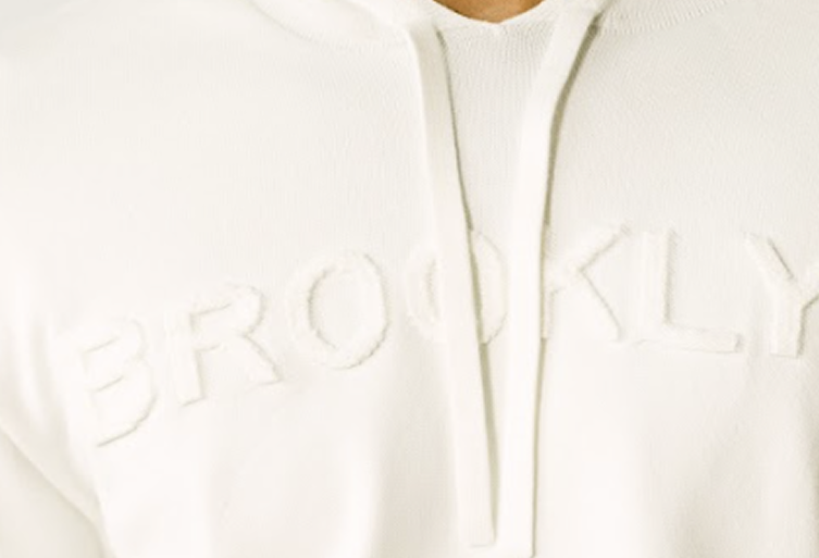 Tonal embossed BROOKLYN lettering on a cream knit hoodie